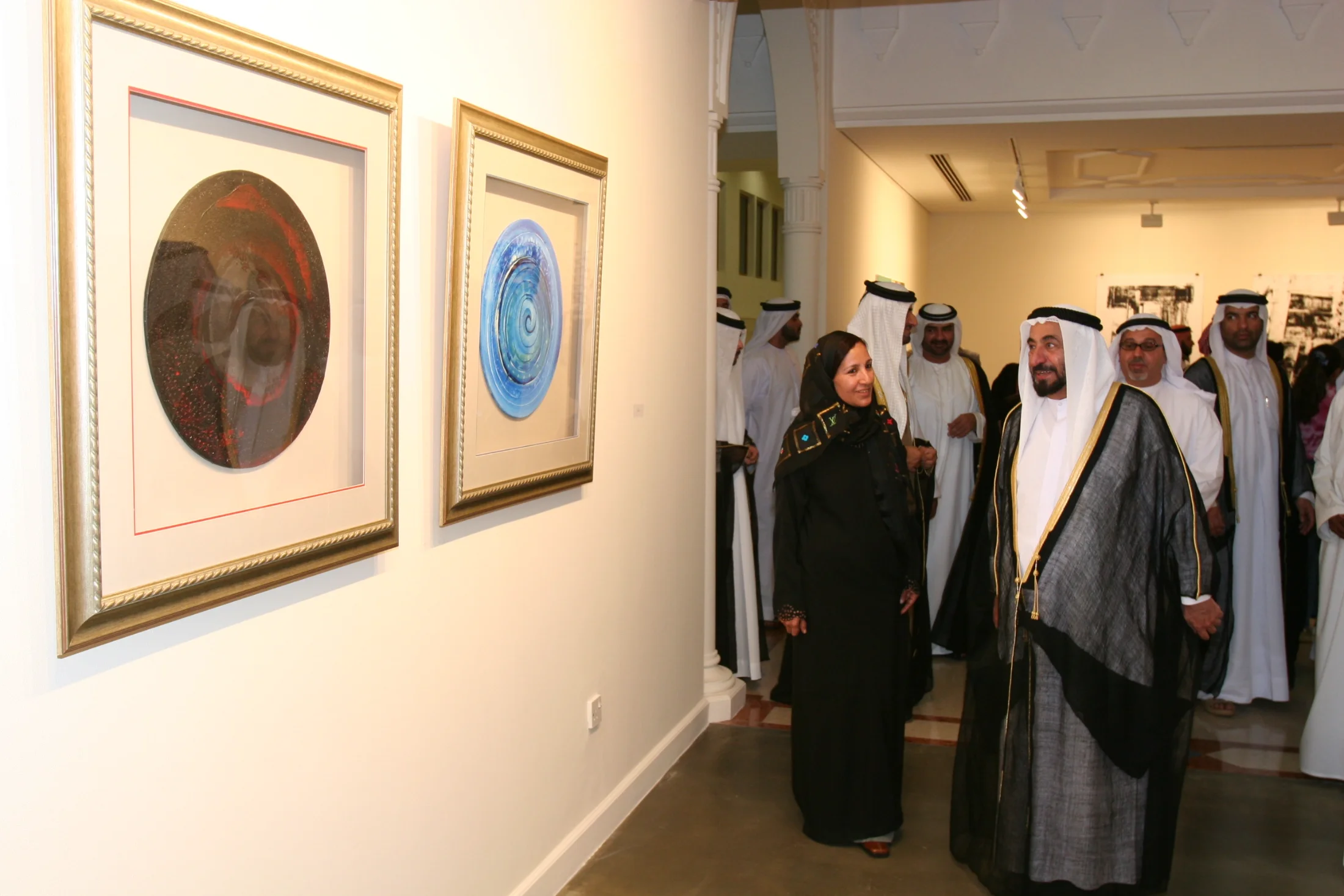 This historic photograph captures a defining moment in Emirati art history. Taken in 2005 at the Sharjah Art Museum, it shows Dr. Najat Makki presenting her solo work directly to His Highness Sheikh Dr. Sultan bin Muhammad Al Qasimi. This interaction reflects both the personal dedication of Dr. Makki to advancing contemporary art in the region and the visionary leadership of Sheikh Sultan, whose unwavering support transformed Sharjah into a global cultural hub.