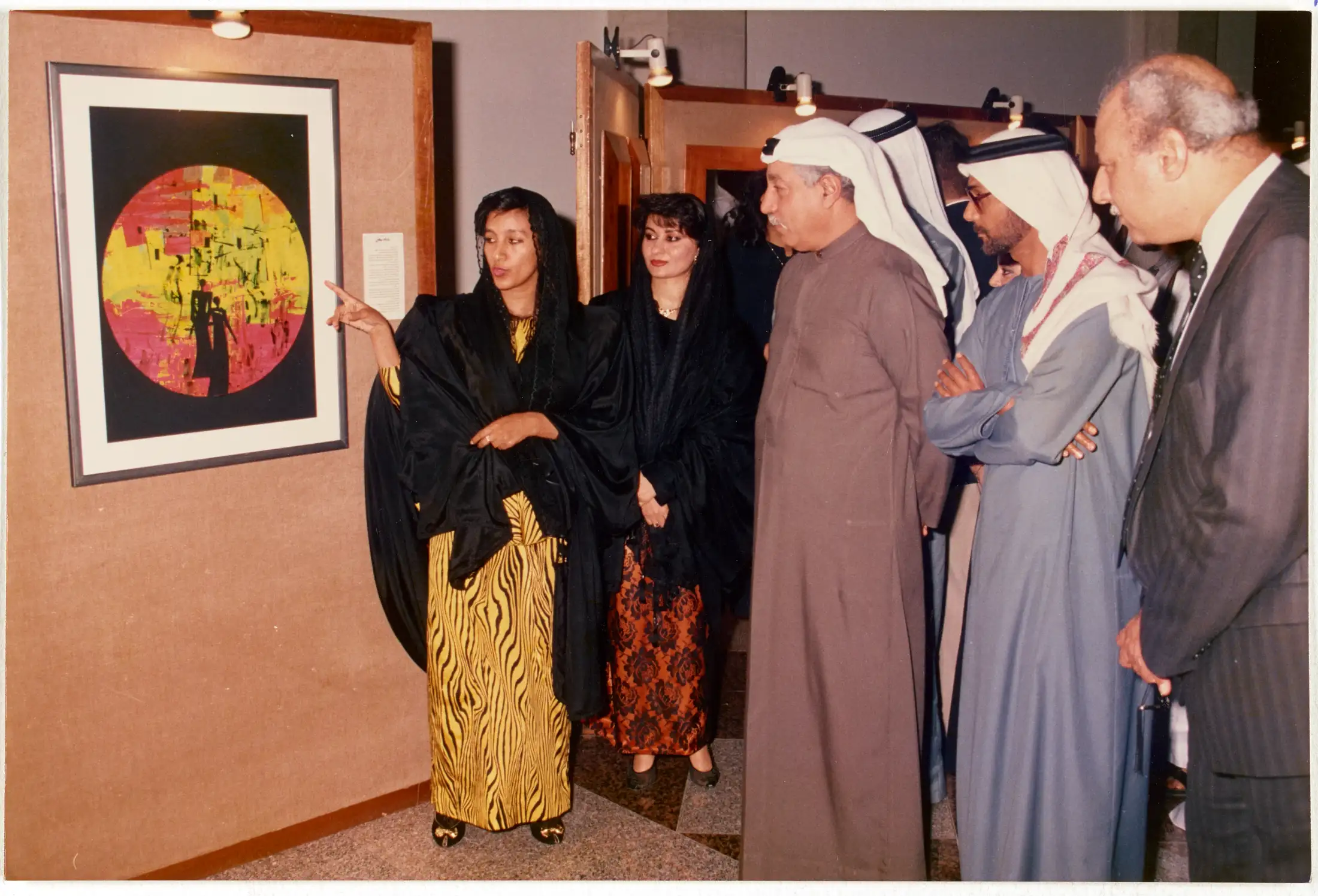 This archival photograph documents Dr. Najat Makki presenting her artwork during an official exhibition opening in the UAE (c. late 1980s–1990s).